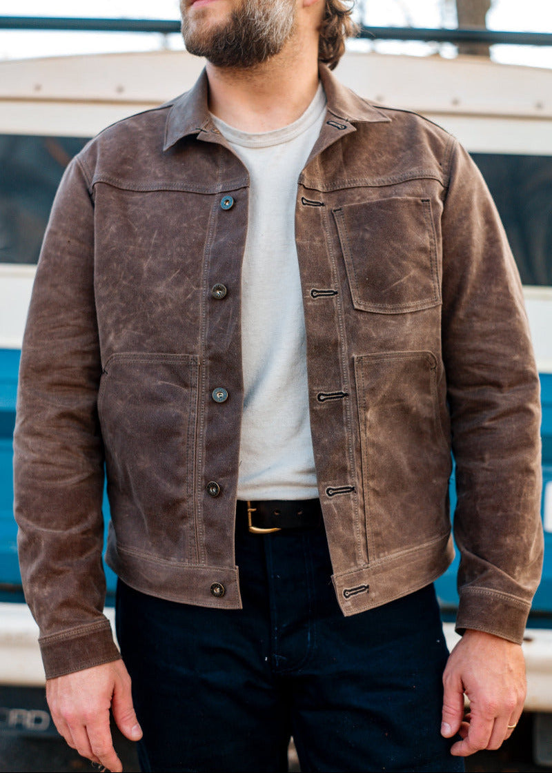 Man wearing a brown suede jacket with a blurred background