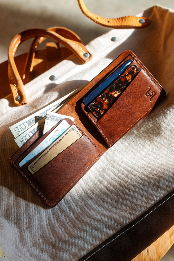 Brown leather wallet with card slots on a beige bag