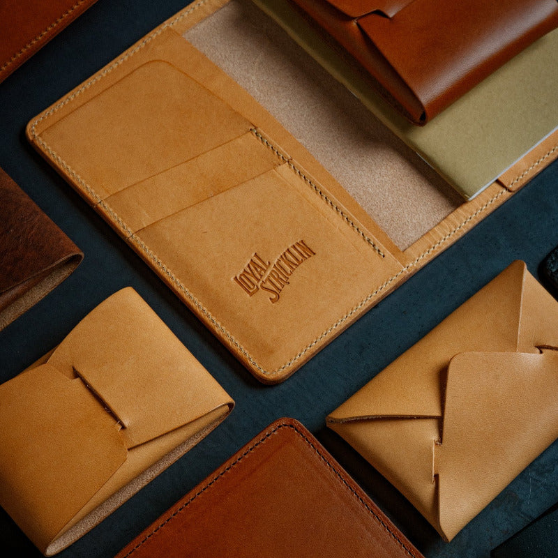 Collection of brown leather wallets on a dark surface