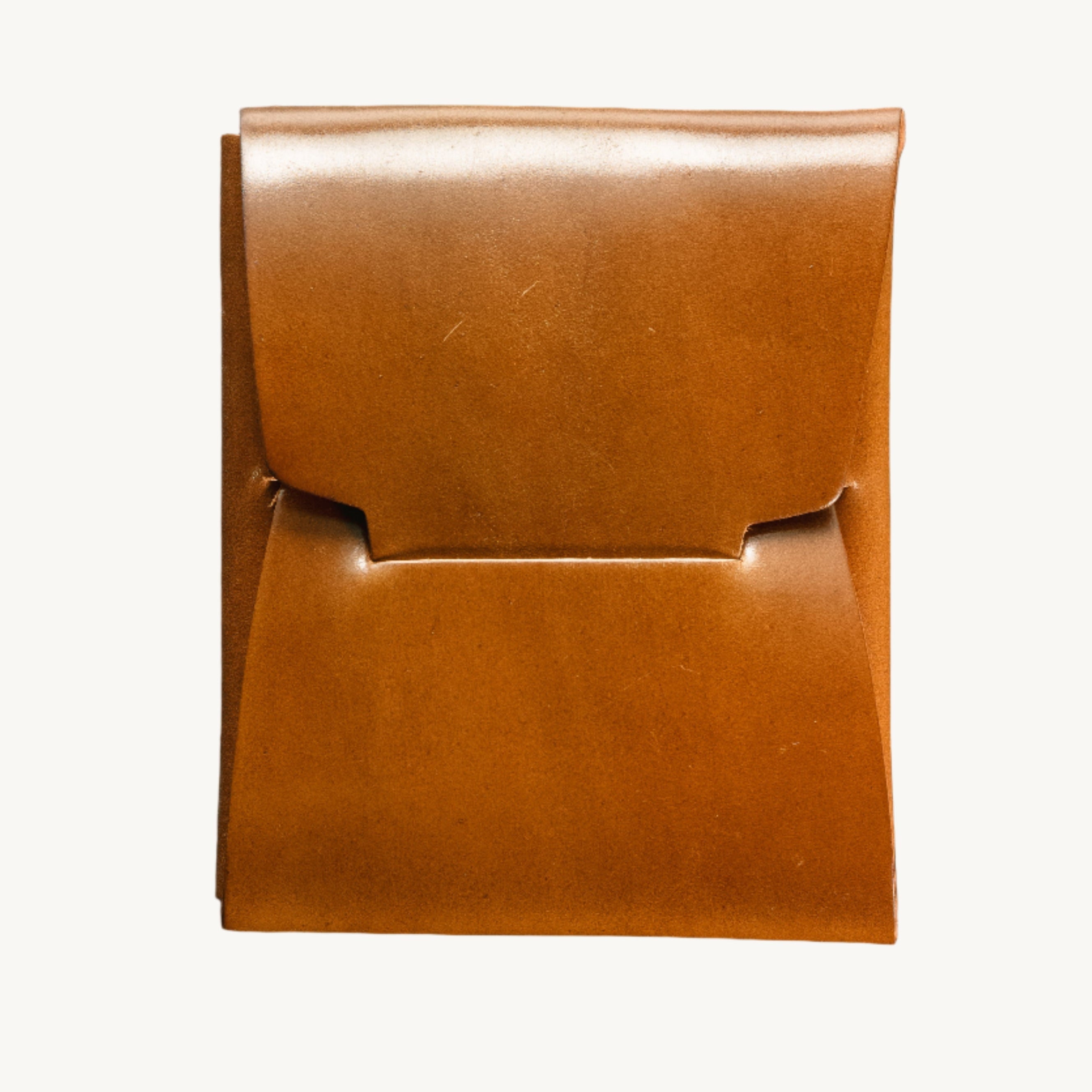 A brown Horween bourbon shell Cordovan leather wallet on a dark textured surface.